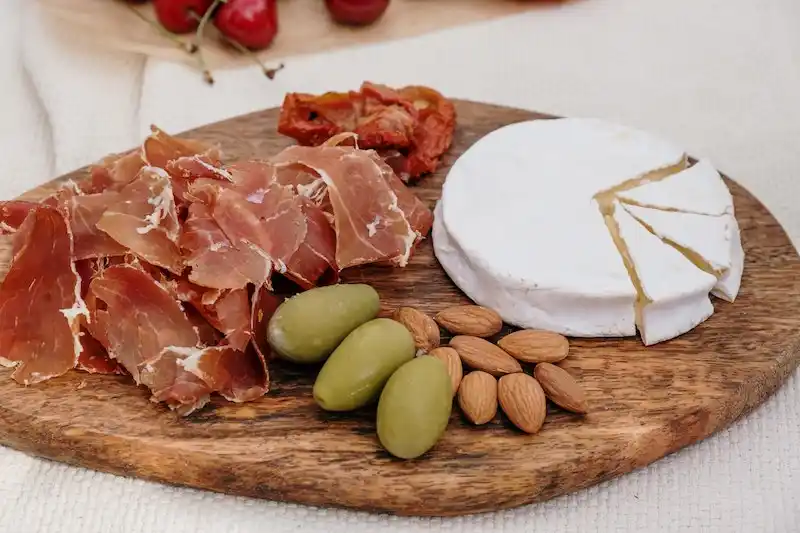 charcuterie board with cheese, meat, and nuts